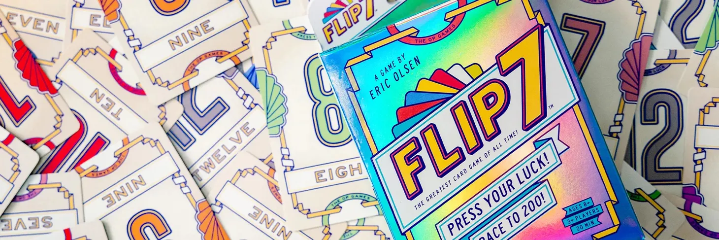 Flip7 cards are spread across a surface, with the Flip7 box sitting on top.