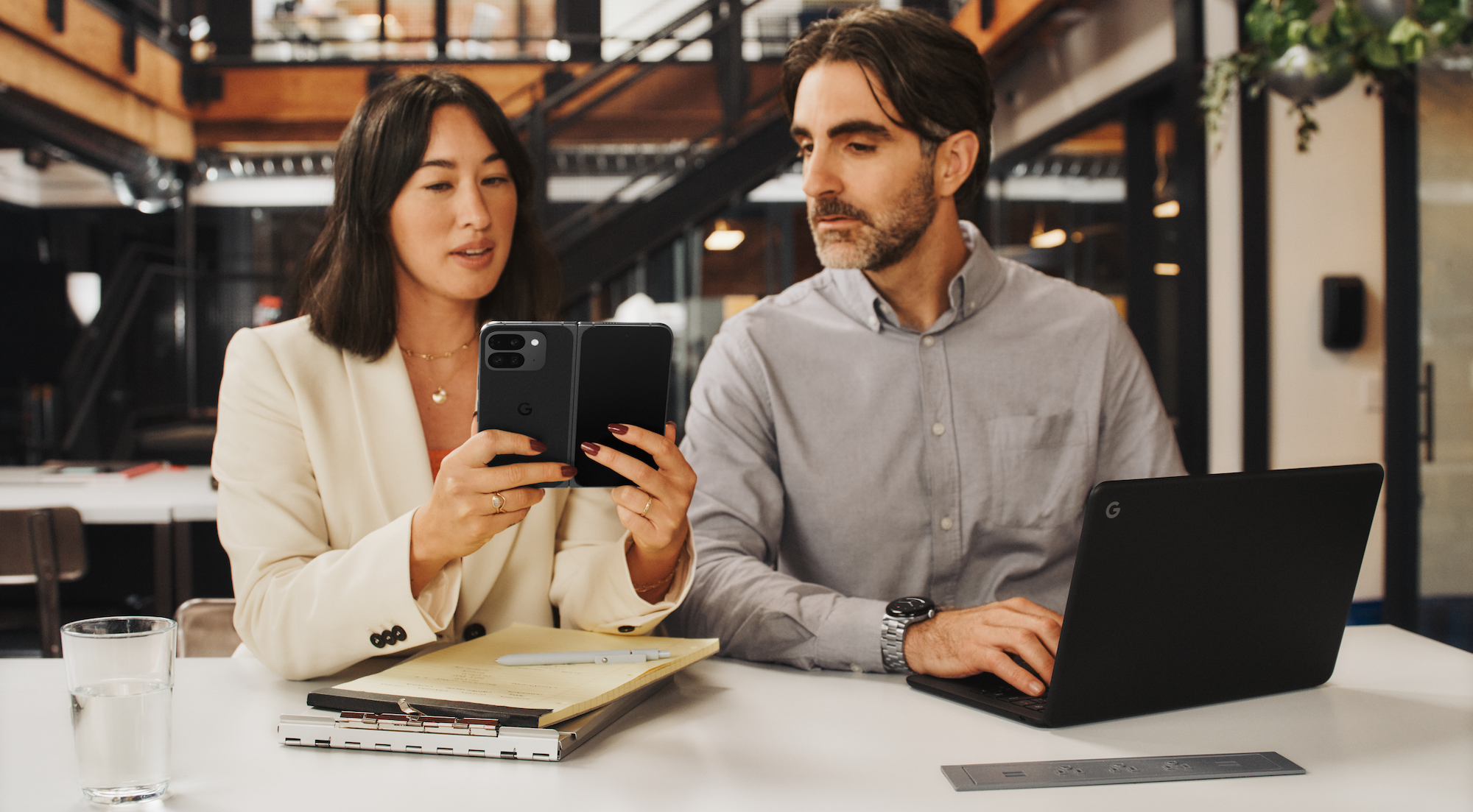 Women, left, and man, right, look at a Pixel 9 Pro Fold in a work context.