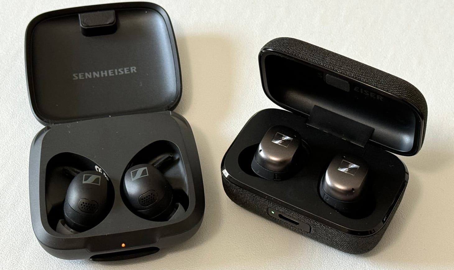 Two pairs of Sennheiser earbuds in cases for comparison.