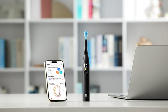 The Oclean X Ultra S toothbrush with the iOS app open on a phone showing brushing information.